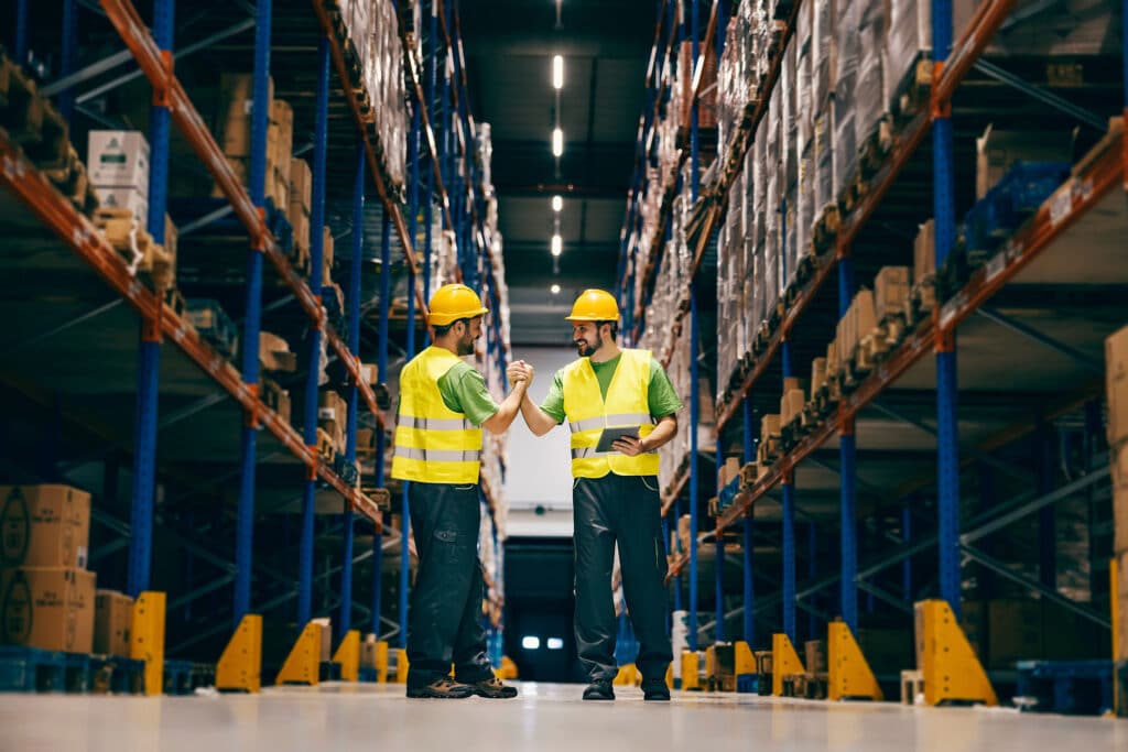 Two storage workers having bro handshake.